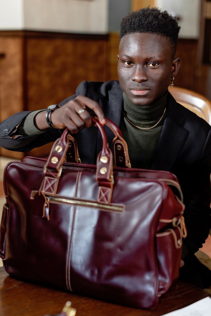 The Art of Drawing Readers In: Your attractive post title goes here Confident man holding a sophisticated leather bag in an office setting.